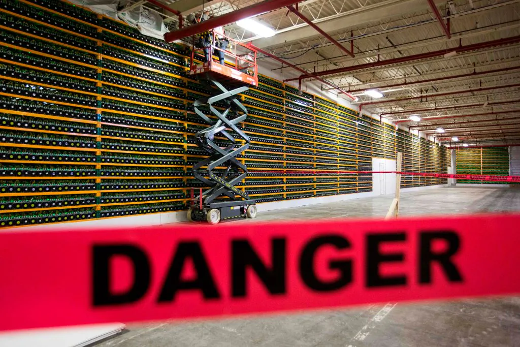 Two construction workers use a lift along a wall of bitcoin mining at Bitfarms in Saint Hyacinthe, Quebec, on March 19, 2018. (Lars Hagberg/AFP via Getty Images)