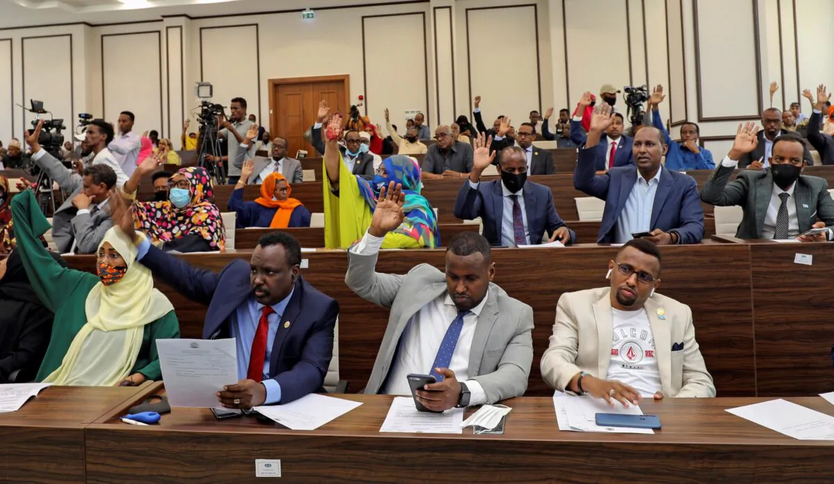 Somalia legislators vote by rising their hands to cancel a divisive two-year presidential term extension, inside the lower house of Parliament in Mogadishu, Somalia, on May 1, 2021. (Feisal Omar/Reuters)