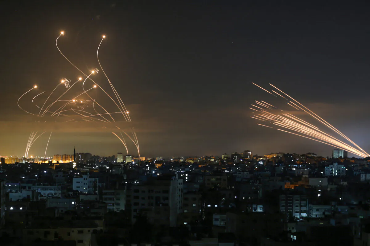 Israel's Iron Dome missile defense system (L) intercepts rockets (R) fired by the Hamas movement toward southern Israel from Beit Lahia in the northern Gaza Strip as seen in the sky above the Gaza Strip overnight on May 14, 2021. (Anas Baba/AFP via Getty Images)
