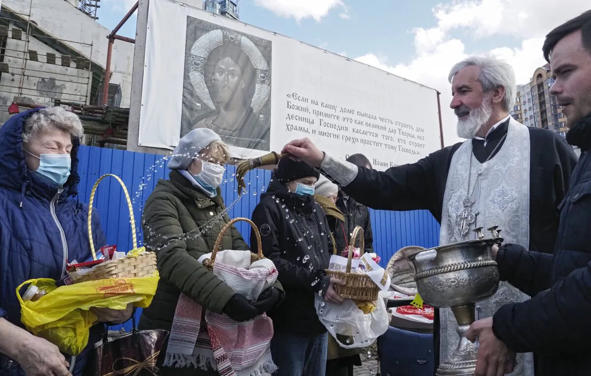 An Orthodox priest blesses traditional Easter cakes and painted eggs prepared for Easter celebration at a church in St. Petersburg, Russia, on May 1, 2021. (Dmitri Lovetsky/AP Photo)
