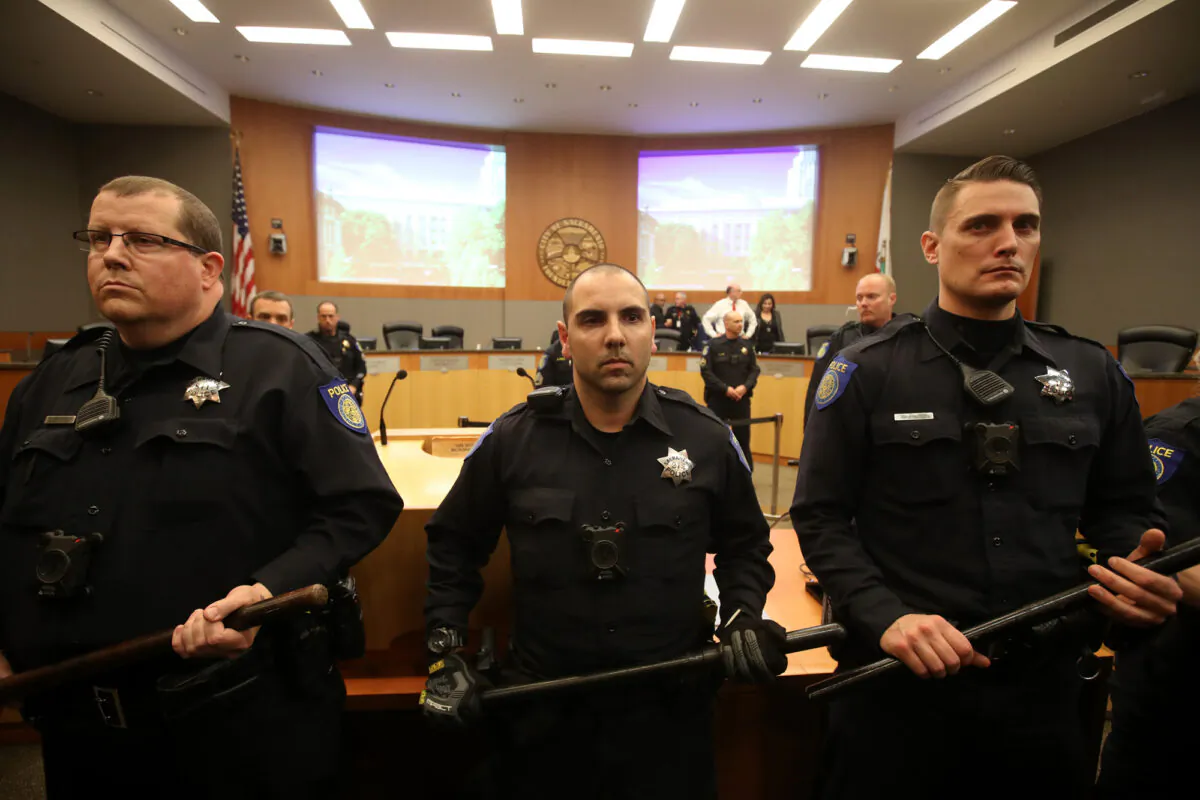 Sacramento police officers guard the dais as activists disrupt the Sacramento city council meeting in Sacramento, Calif., on March 5, 2019. (Justin Sullivan/Getty Images)