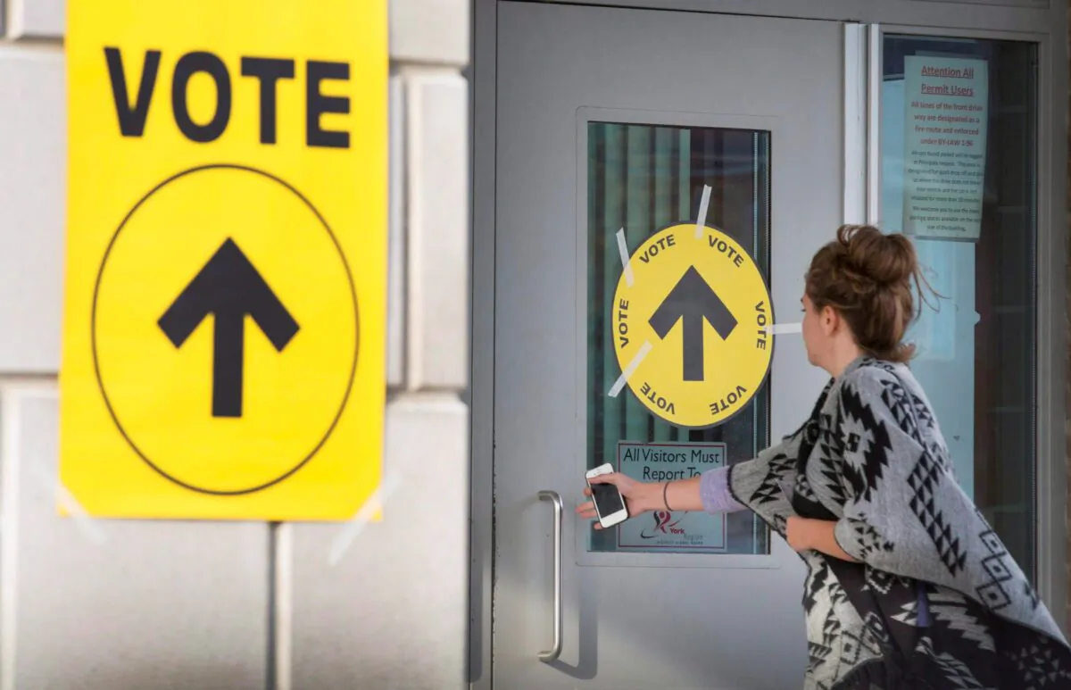 A woman enters a polling place to cast her vote in the federal election on Oct. 19, 2015. (The Canadian Press/Peter Power)