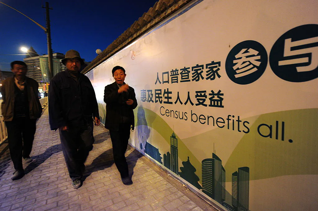 Pedestrians walk past a billboard for China's coming census in Beijing on Oct. 29, 2010. (Frederic J. Brown/AFP via Getty Images)