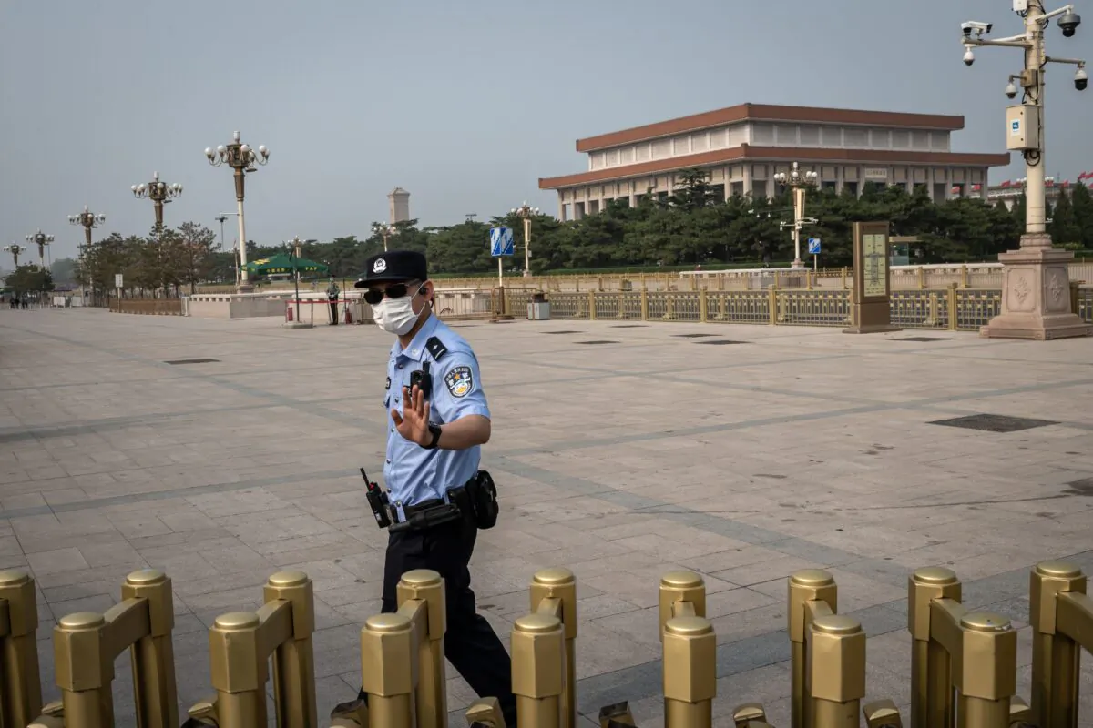 A police officer gestures as he secures an area outside Beijing's Tiananmen Square (back) on World Press Freedom Day on May 3, 2020. (Nicolas Asfouri/AFP via Getty Images)
