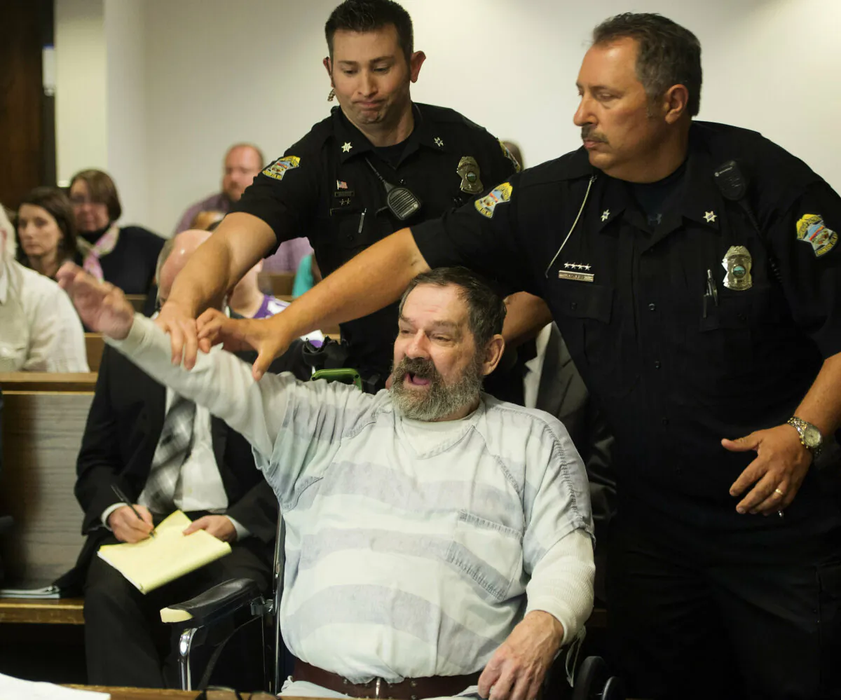 Frazier Glenn Miller Jr., convicted of capital murder, attempted murder and other charges, gestures as Johnson County deputies remove Miller from the courtroom during the sentencing phase of his trial at the Johnson County District Court in Olathe, Kan., on Nov. 10, 2015. (Joe Ledford/Pool/The Kansas City Star via AP)