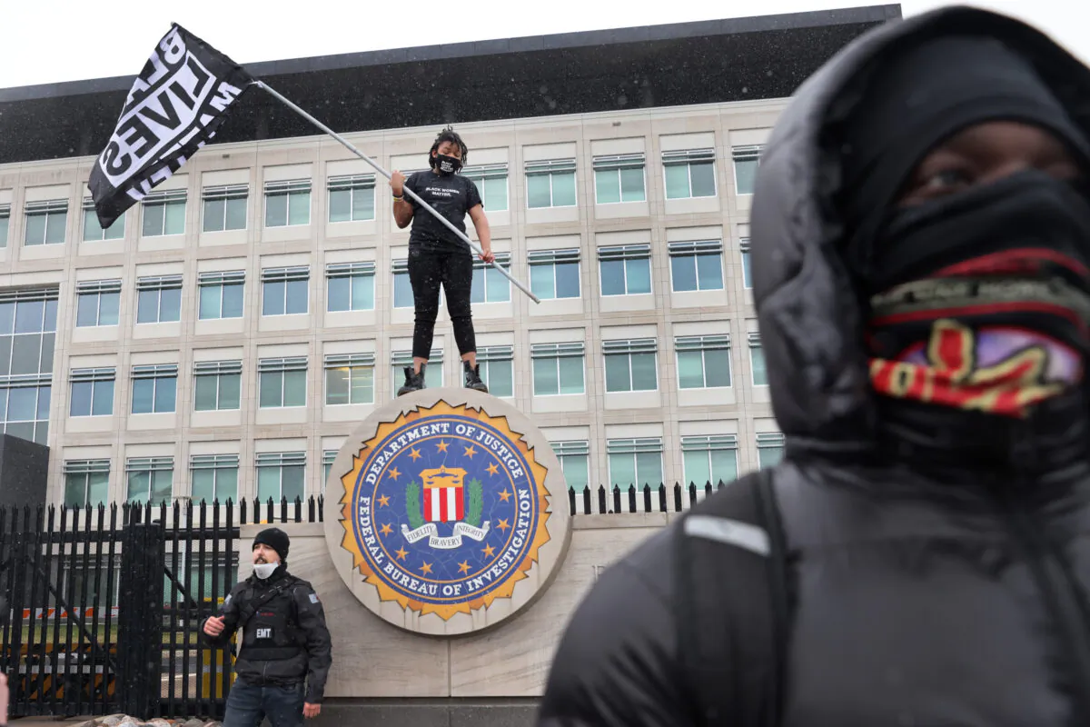 Demonstrators pause in front of the FBI offices during a march from the Brooklyn Center police station in Brooklyn Center, Minn., on April 13, 2021. (Scott Olson/Getty Images)