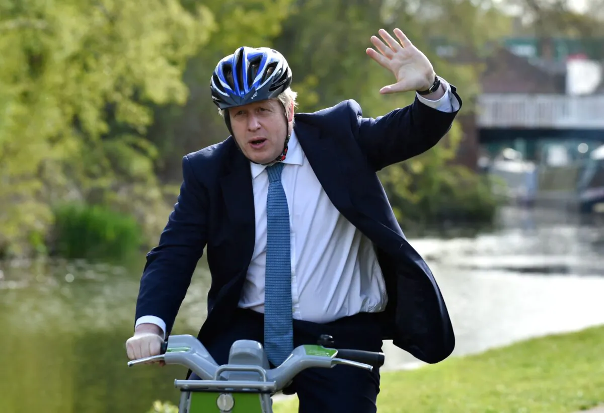 British Prime Minister Boris Johnson rides a bike on the towpath of the Stourbridge canal during a Conservative party local election visit in Stourbridge, central England, on May 5, 2021. (Rui Vieira/Pool/AFP via Getty Images)