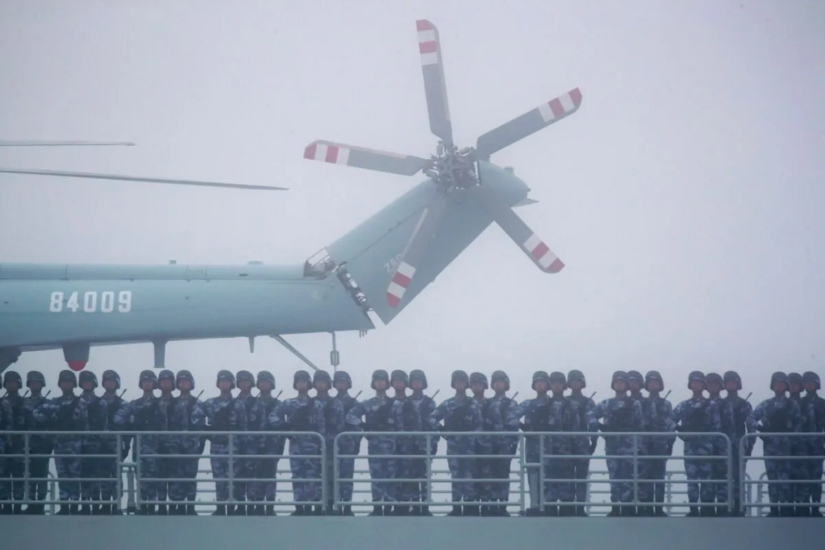 Soldiers stand on deck of the ambitious transport dock Yimen Shan of the Chinese People's Liberation Army (PLA) Navy as it participates in a naval parade to commemorate the 70th anniversary of the founding of China's PLA Navy in the sea near Qingdao in eastern China's Shandong province, on April 23, 2019. (Mark Schiefelbein/AFP via Getty Images)