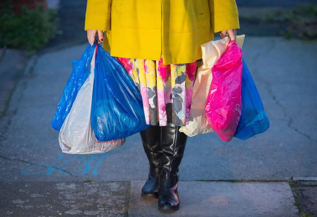 A shopping being carried in plastic carrier bags. Picture issued on May 7, 2021. (PA)