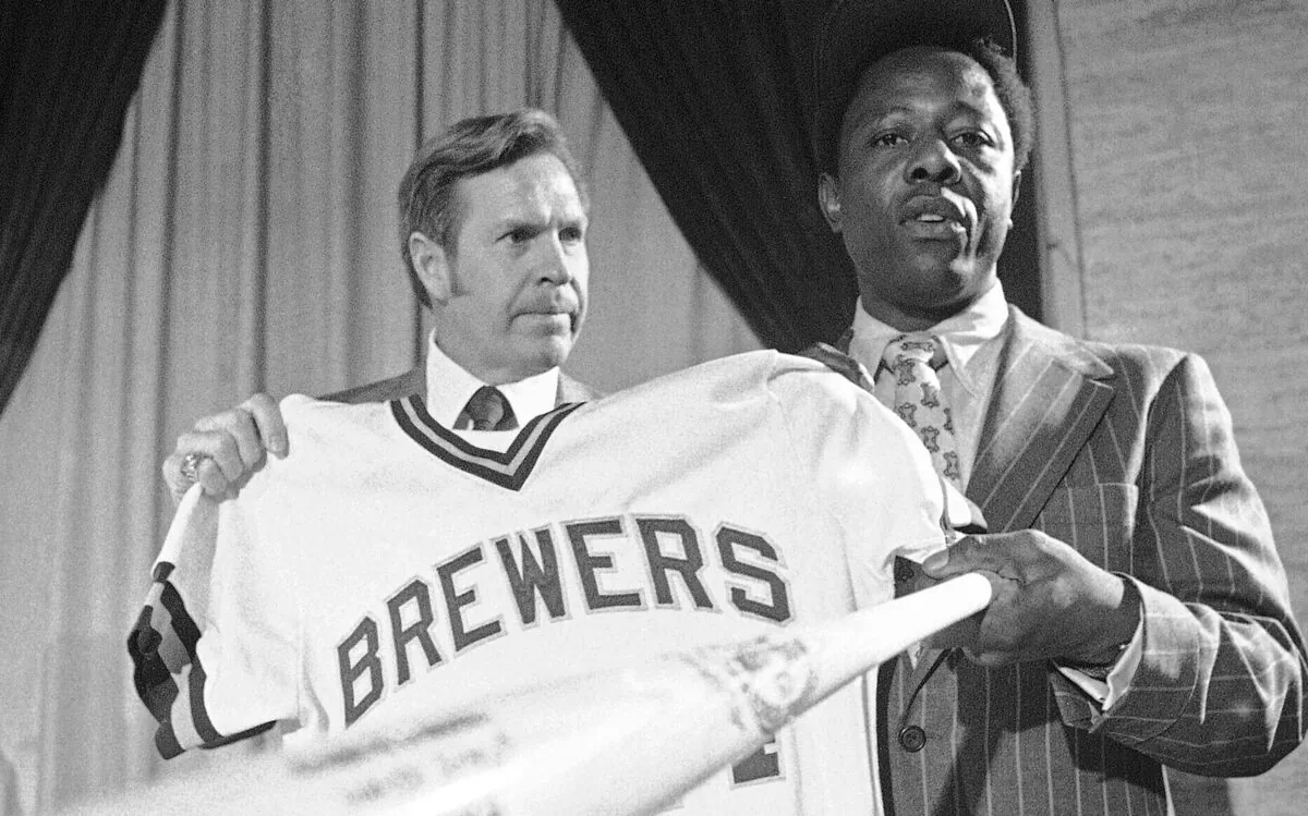 Milwaukee Brewers manager Del Crandall (L) and Henry Aaron display Aaron's new Brewers jersey and a bat during a news conference in Milwaukee to announce signing Aaron, on Nov. 14, 1974. (Paul Shane/AP Photo)