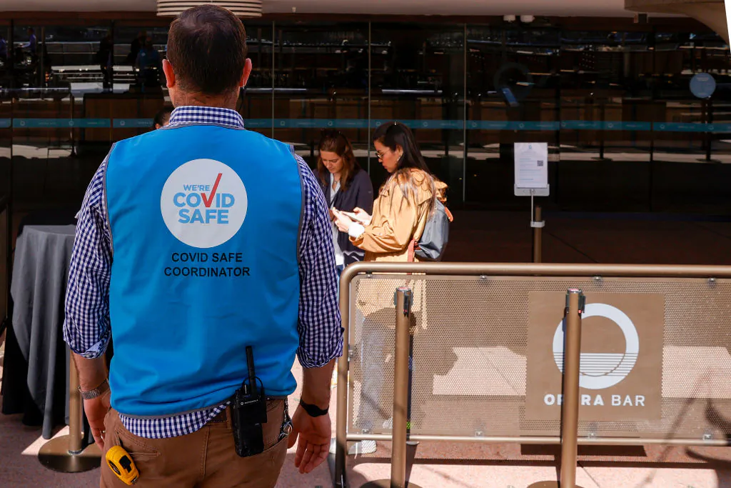 A COVID safe coordinator looks on outside the Opera Bar at Sydney Opera House on Sept. 10, 2020, in Sydney, Australia. (Jenny Evans/Getty Images)