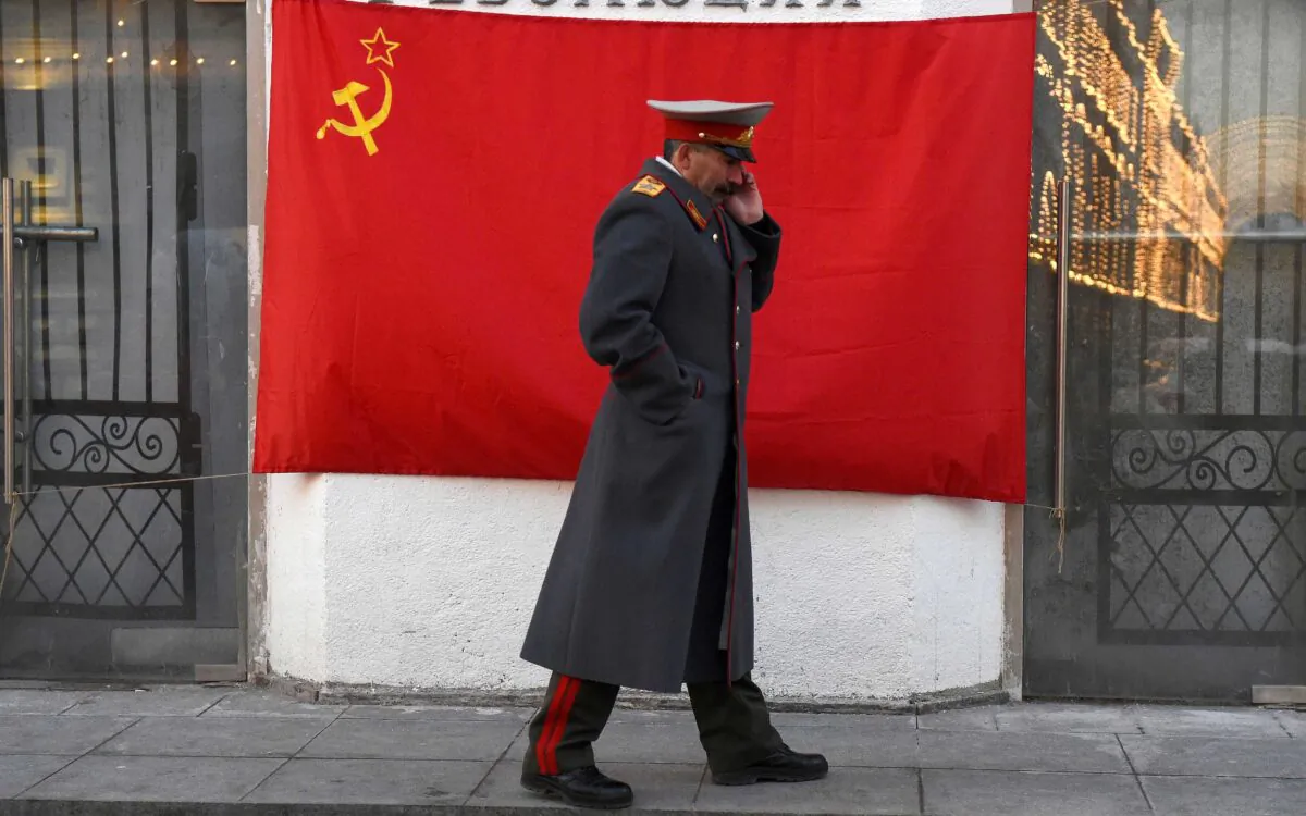 An impersonator of Soviet leader Joseph Stalin walks past a hammer-and-sickle red flag in central Moscow on Nov. 21, 2016. (Vasily Maximov/AFP via Getty Images)