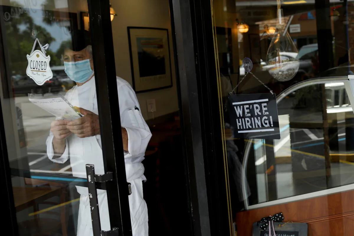 A sign advertising jobs at the entrance of a restaurant, as Miami-Dade County eases some of the lockdown measures put in place during the COVID-19 outbreak, in Miami, Fla., on May 18, 2020. (Marco Bello/Reuters)