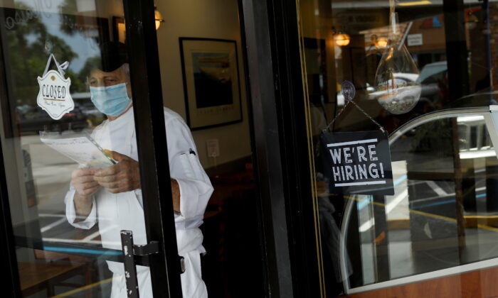 A sign advertising jobs at the entrance of a restaurant, as Miami-Dade County eases some of the lockdown measures put in place during the COVID-19 outbreak, in Miami, Fla., on May 18, 2020. (Marco Bello/Reuters)