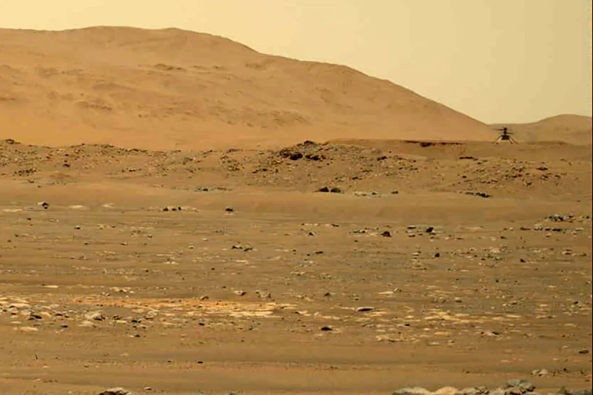 In this image taken by the Mars Perseverance rover and made available by NASA, the Mars Ingenuity helicopter (R) flies over the surface of the planet on April 30, 2021. (NASA/JPL-Caltech/ASU/MSSS via AP)