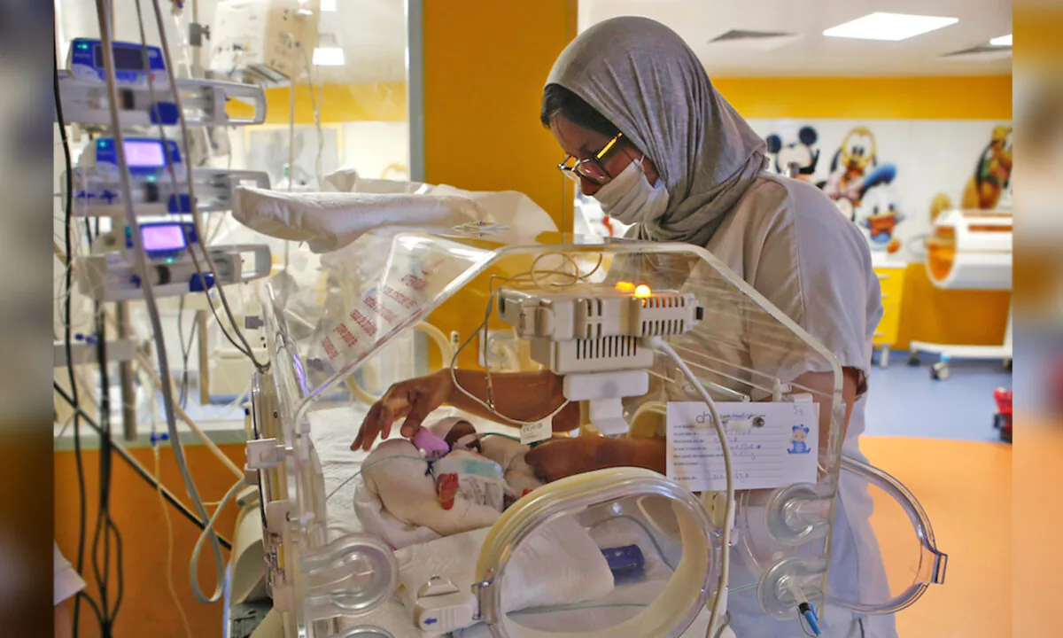 A Moroccan nurse takes care of one of the nine babies protected in an incubator at the maternity ward of the private clinic of Ain Borja in Casablanca, Morocco. (Abdeljalil Bounhar/AP Photo)
