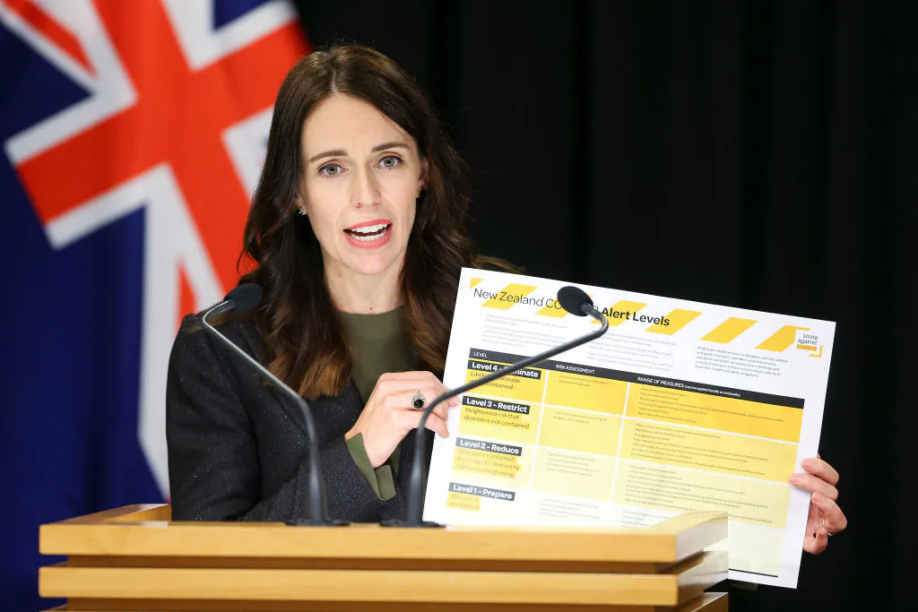 Prime Minister Jacinda Ardern holds up information on COVID-19 alert levels during a press conference at Parliament in Wellington, New Zealand on March 21, 2020. (Hagen Hopkins/Getty Images)