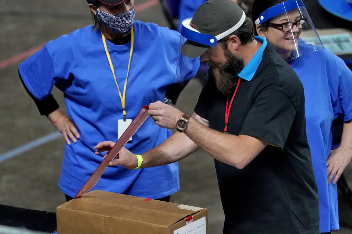 Maricopa County ballots cast in the 2020 general election are unsealed to be examined and recounted by contractors working under a contract with the Arizona Senate, at Veterans Memorial Coliseum in Phoenix, Ariz., on May 6, 2021. (Matt York/Pool/AP Photo)