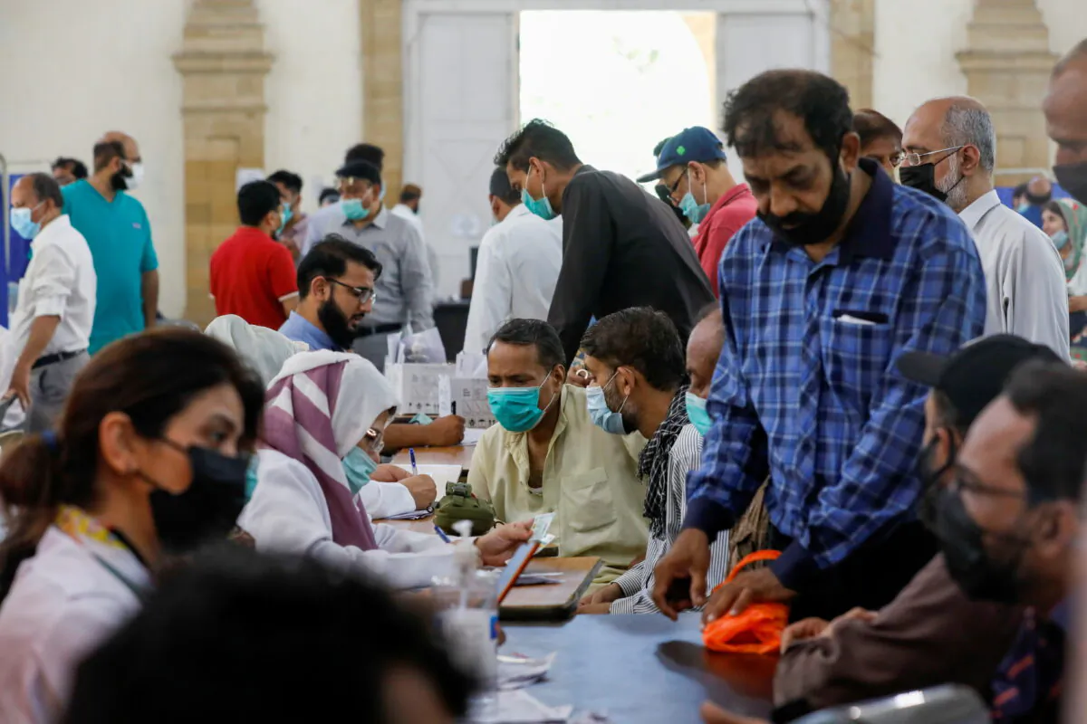 People gather to receive their CCP virus disease (COVID-19) vaccine doses, at a vaccination center in Karachi, Pakistan, on April 28, 2021. (Akhtar Soomro/Reuters)