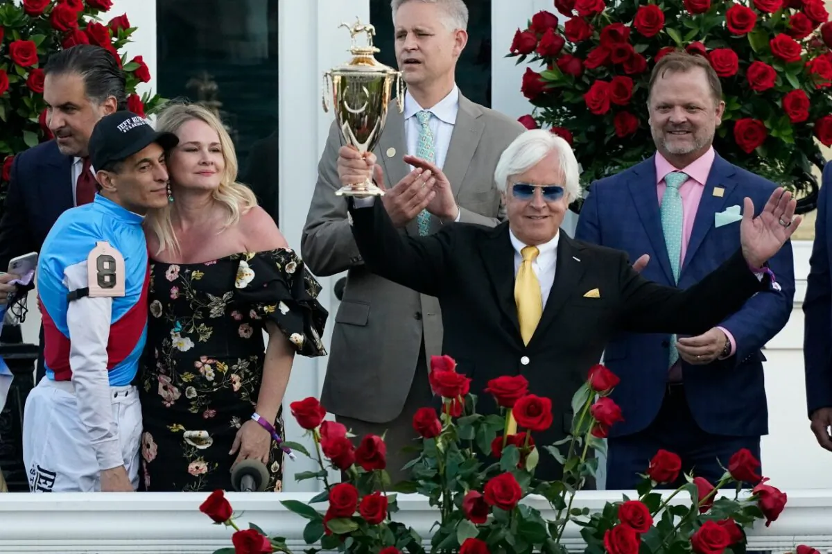 Jockey John Velazquez (L) watches as trainer Bob Baffert holds up the winner's trophy after they victory with Medina Spirit in the 147th running of the Kentucky Derby at Churchill Downs,  in Louisville, Ky., on May 1, 2021. (Jeff Roberson/AP Photo)