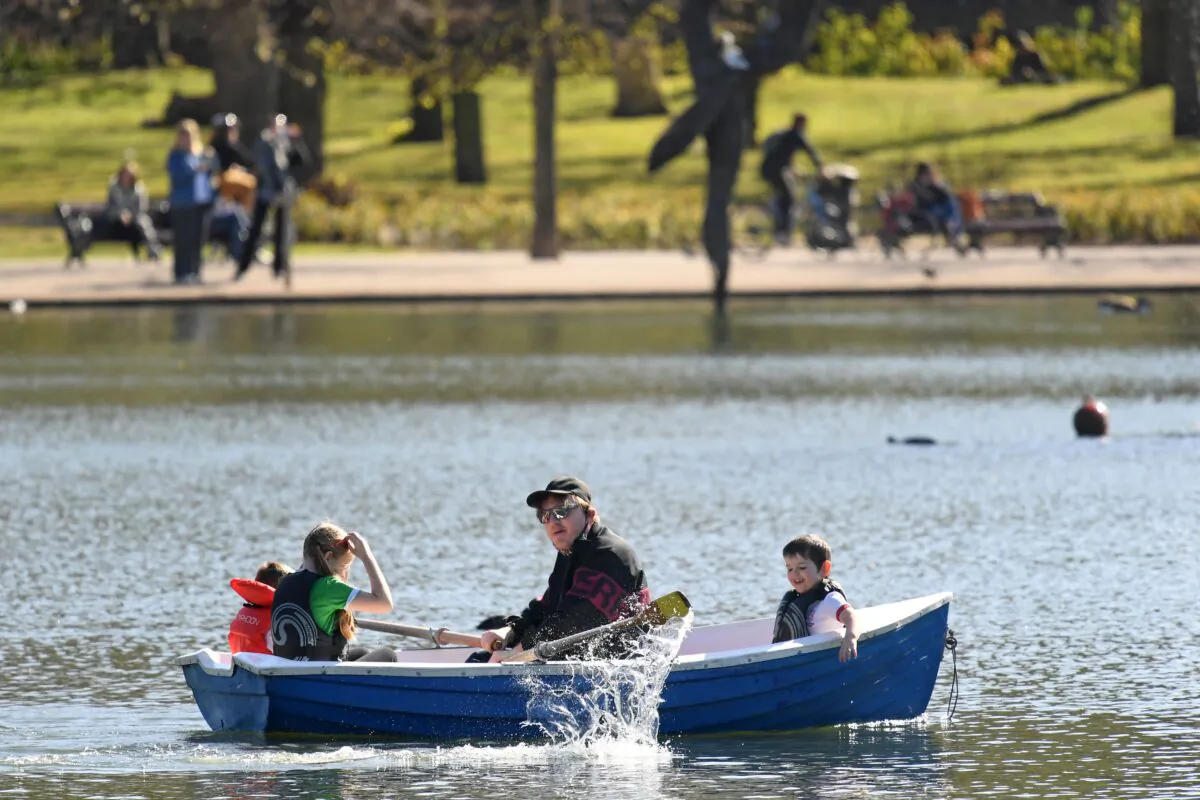 Children are rowed across the lake in the spring sunshine in Victoria Park, east London, on April 22, 2021. (Daniel Leal-Olivas/AFP via Getty Images)