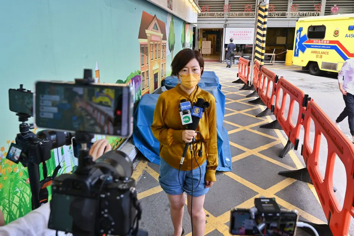 Sarah Liang, a reporter for the Hong Kong edition of The Epoch Times, speaks to local media outside of the Queen Elizabeth Hospital in Hong Kong on May 11, 2021. (Song Pi-lung/The Epoch Times)