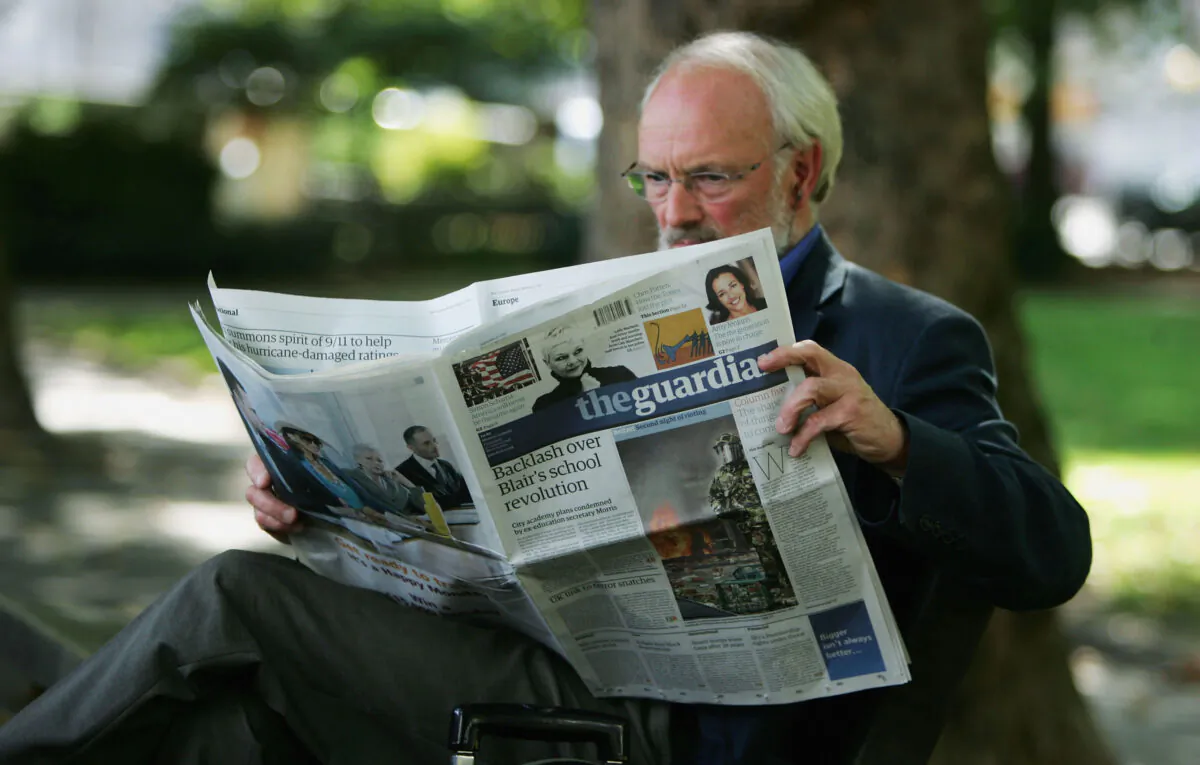 A man reads a copy of The Guardian newspaper in London, England, on Sept. 12, 2005. (Scott Barbour/Getty Images)