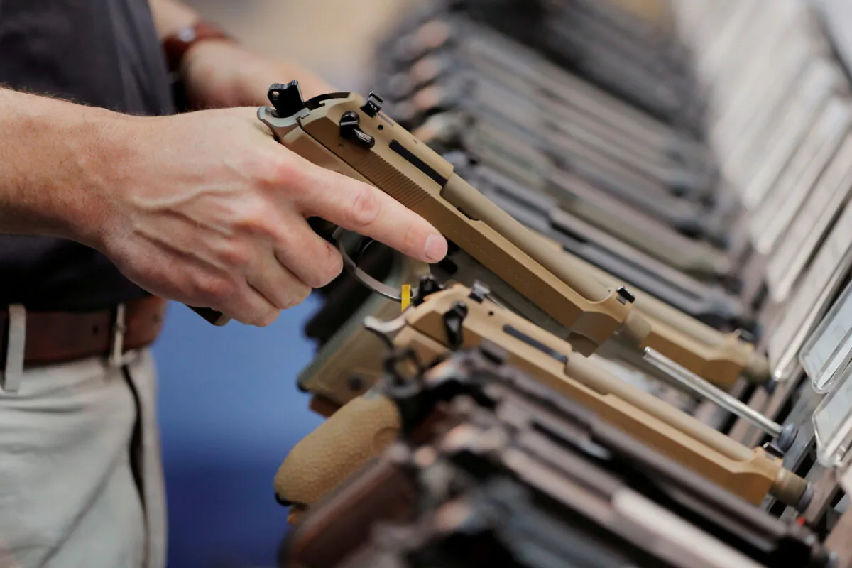 A man inspects a handgun inside of the Beretta booth during the National Rifle Association annual meeting in Indianapolis, Indiana, on April 28, 2019. (Lucas Jackson/Reuters File Photo)