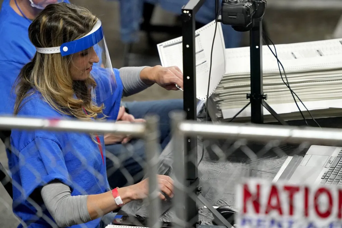 Workers examine ballots cast in Maricopa County in the 2020 election during an audit at Veterans Memorial Coliseum in Phoenix, Ariz., on May 6, 2021. (Matt York/AP Photo)