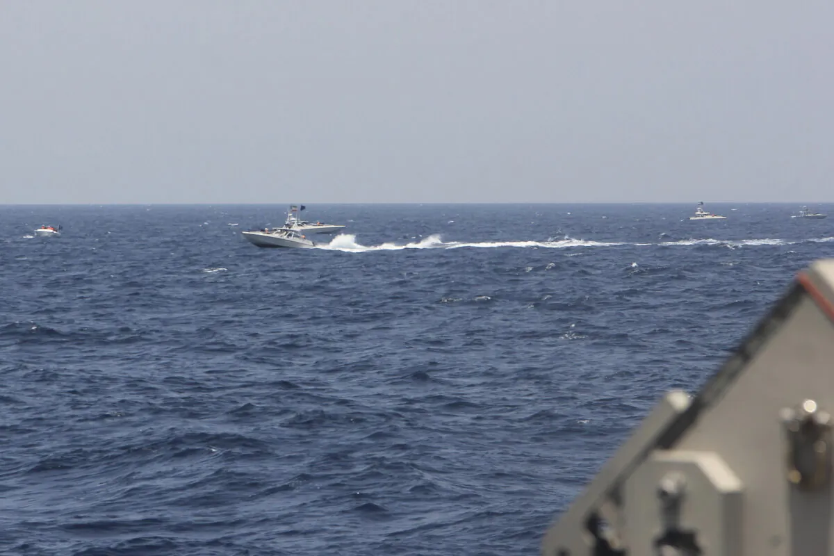 An Iranian Islamic Revolutionary Guard Corps Navy (IRGCN) fast in-shore attack craft (FIAC), a type of speedboat armed with machine guns, speeds near U.S. naval vessels transiting the Strait of Hormuz, on May 10, 2021. (U.S. Navy via AP)