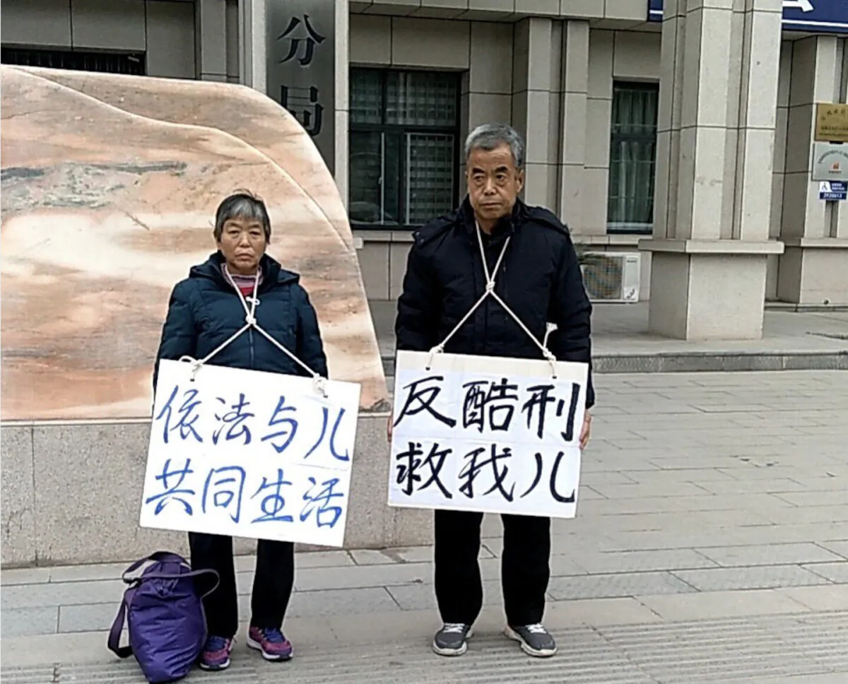 The parents of Chinese lawyer Chang Weiping protest the torture of their son in front of the Gaoxin branch of the Baoji City Public Security Bureau, China, on Dec. 14, 2020. (The Epoch Times)