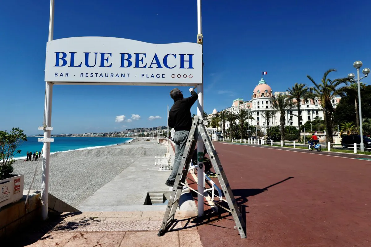 A man uses a ladder during preparations for the reopenning of restaurants and beaches in Nice as part of an easing of the country's lockdown restrictions amid the COVID-19 outbreak in France, on May 3, 2021.  (Eric Gaillard/Reuters)