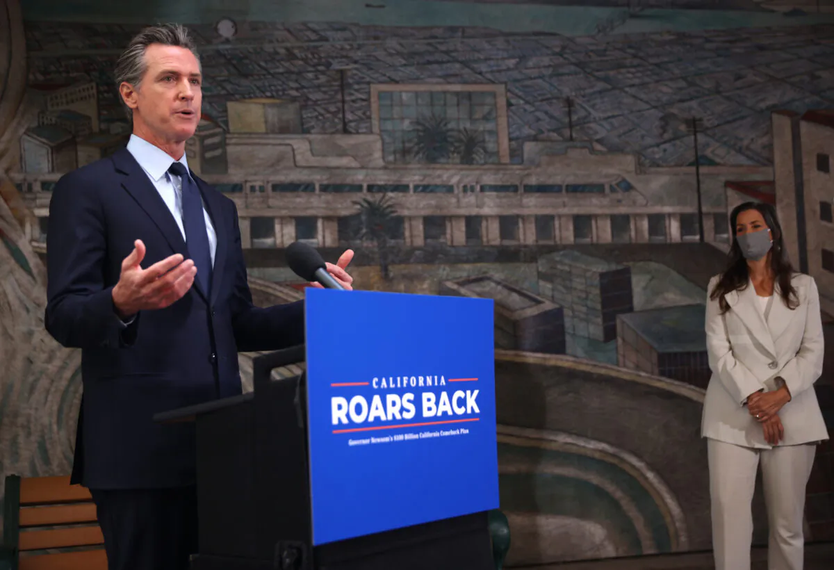 California Gov. Gavin Newsom (L) speaks during a press conference as Oakland Mayor Libby Schaff (R) looks on at The Unity Council in Oakland, Calif., on May 10, 2021. (Justin Sullivan/Getty Images)