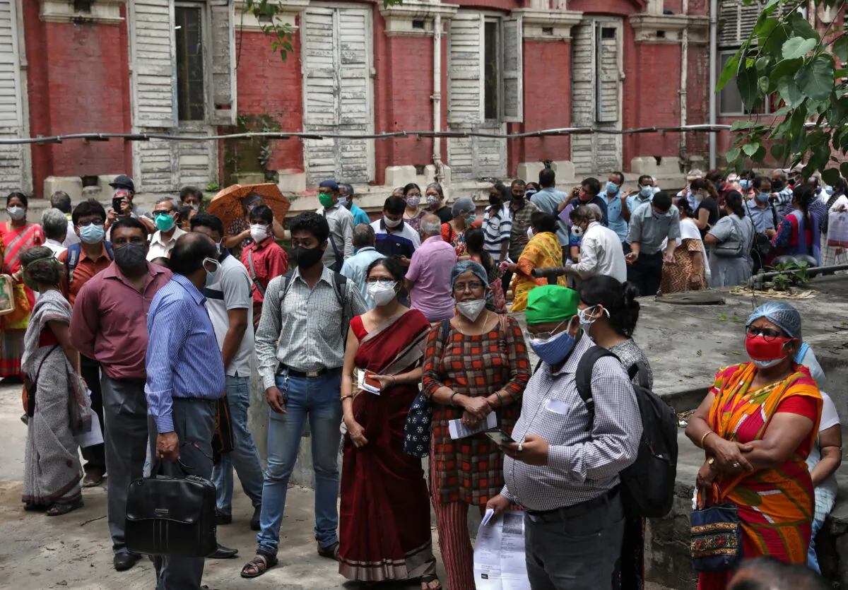 People wearing protective face masks wait to receive their second dose of COVISHIELD, a COVID-19 vaccine manufactured by Serum Institute of India, outside a vaccination centre in Kolkata, India, May 12, 2021. (Rupak De Chowdhuri/Reuters)