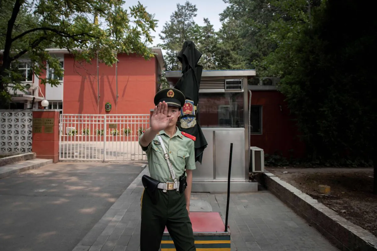 A paramilitary police officer gestures outside the Belgium embassy in Beijing on June 19, 2019. - A Belgian diplomat was expected to travel to China's restive Xinjiang region on June 18 to confirm the whereabouts of a Uyghur family that was escorted from Belgium's embassy in Beijing by police last month. (NICOLAS ASFOURI /AFP via Getty Images)