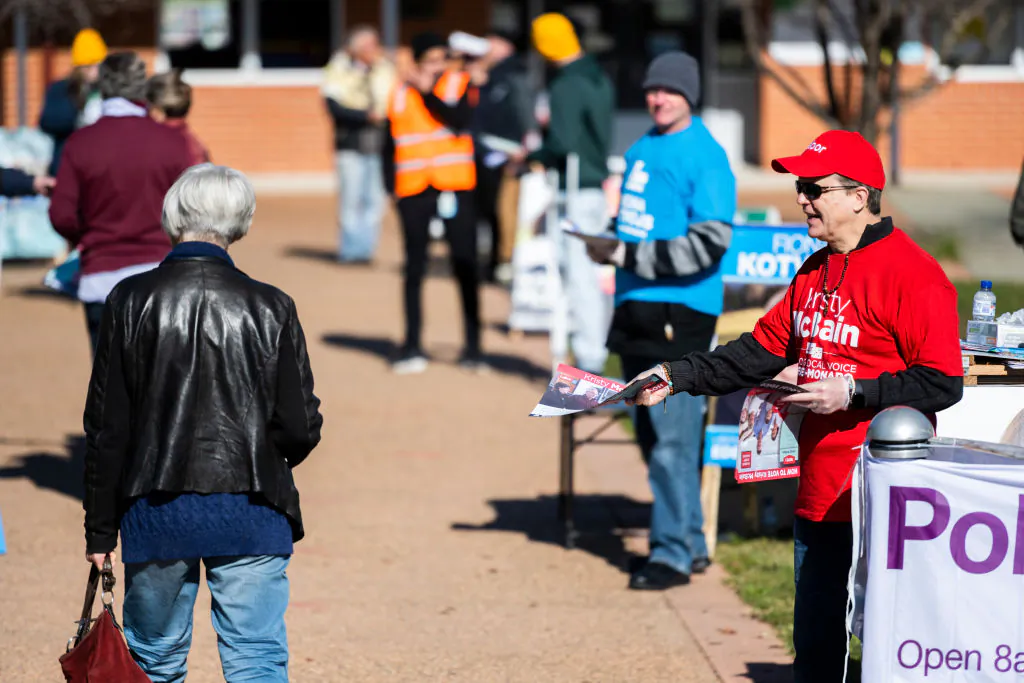 Voters and party representatives interact outside Bungendore Public School on July 04, 2020 in Bungendore, Australia. (Rohan Thomson/Getty Images)