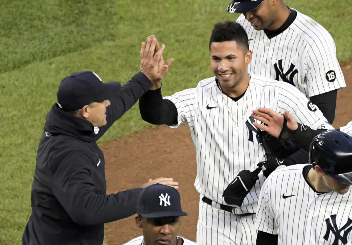 New York Yankees' Gleyber Torres is congratulated by manager Aaron Boone after Torres drove in the winning run in the 11th inning of the team's baseball game against the Washington Nationals at Yankee Stadium in New York City on May 8, 2021. (Bill Kostroun/AP Photo)
