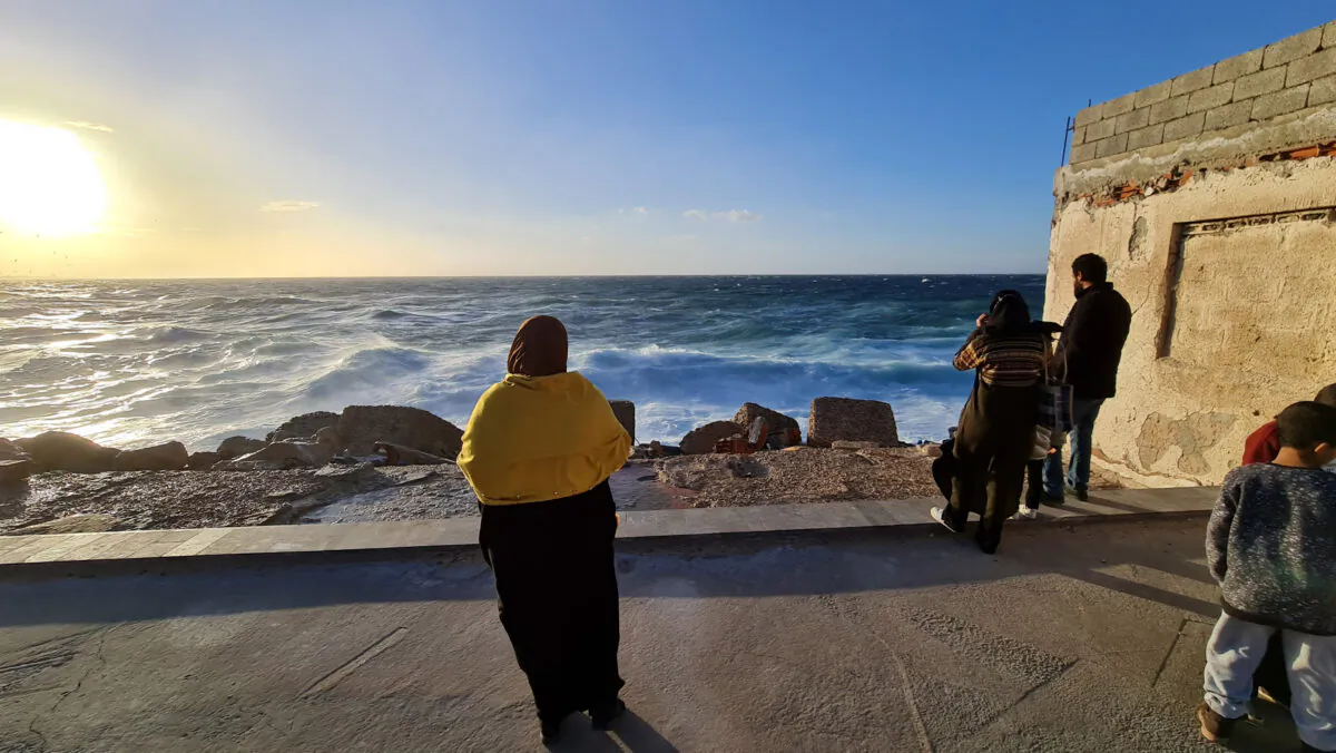 Libyans stand on the shore of the Mediterranean Sea in the capital Tripoli, Libya, on Jan. 26, 2021. (Mahmud Turkia/AFP via Getty Images)