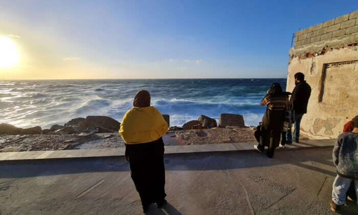 Libyans stand on the shore of the Mediterranean Sea in the capital Tripoli, Libya, on Jan. 26, 2021. (Mahmud Turkia/AFP via Getty Images)