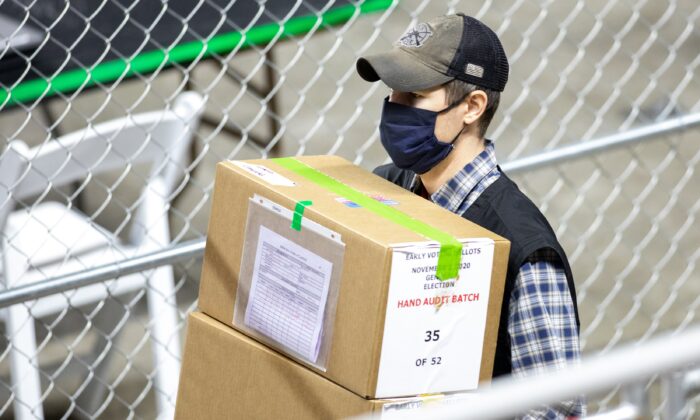 A contractor working for Cyber Ninjas, who was hired by the Arizona Senate, transports ballots from the 2020 General Election at Veterans Memorial Coliseum in Phoenix, Ariz., on May 1, 2021. (Courtney Pedroza/Getty Images)