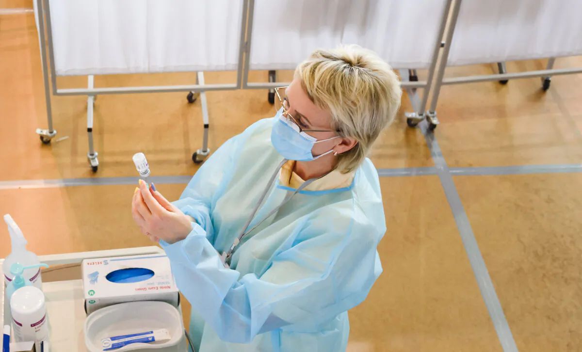 A medical worker prepares a syringe with AstraZeneca vaccine at a local community sports hall converted into a vaccination centre in Ventspils, Latvia, on March 30, 2021. (Gints Ivuskans/AFP via Getty Images)