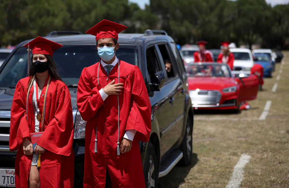 High School seniors recite the pledge of allegiance during a drive-in graduation ceremony in San Francisco, California on June 12, 2020. (Photo by Justin Sullivan/Getty Images)
