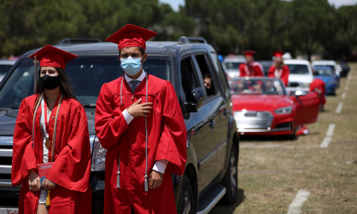 High School seniors recite the pledge of allegiance during a drive-in graduation ceremony in San Francisco, California on June 12, 2020. (Photo by Justin Sullivan/Getty Images)