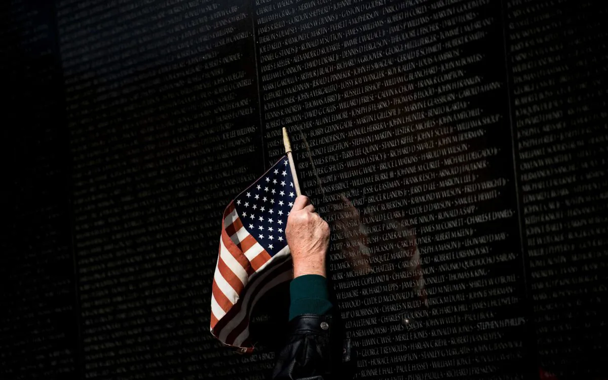A man points to a name while visiting the Vietnam War Memorial on Veterans Day in Washington, D.C. on Nov. 10, 2017. (Brendan Smialowski/AFP via Getty Images)