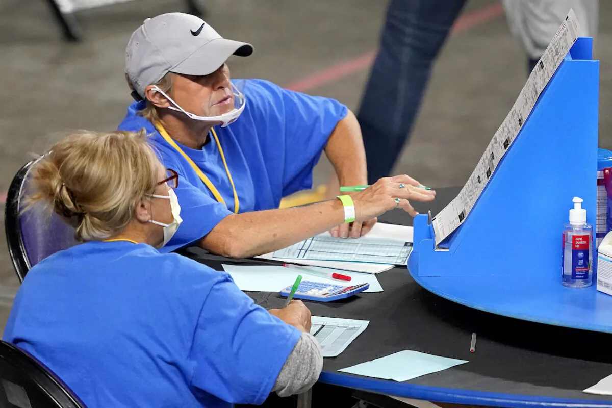 Ballots cast in the 2020 general election are examined and recounted by contractors working for Florida-based company, Cyber Ninjas, at Veterans Memorial Coliseum in Phoenix, Ariz., on May 6, 2021. (Matt York/Pool/AP Photo)