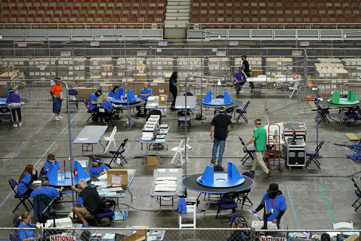 Maricopa County ballots cast in the 2020 general election are examined and recounted by contractors working for Florida-based company, Cyber Ninjas, at Veterans Memorial Coliseum in Phoenix, Ariz., on May 6, 2021. (Matt York/Pool/AP Photo)
