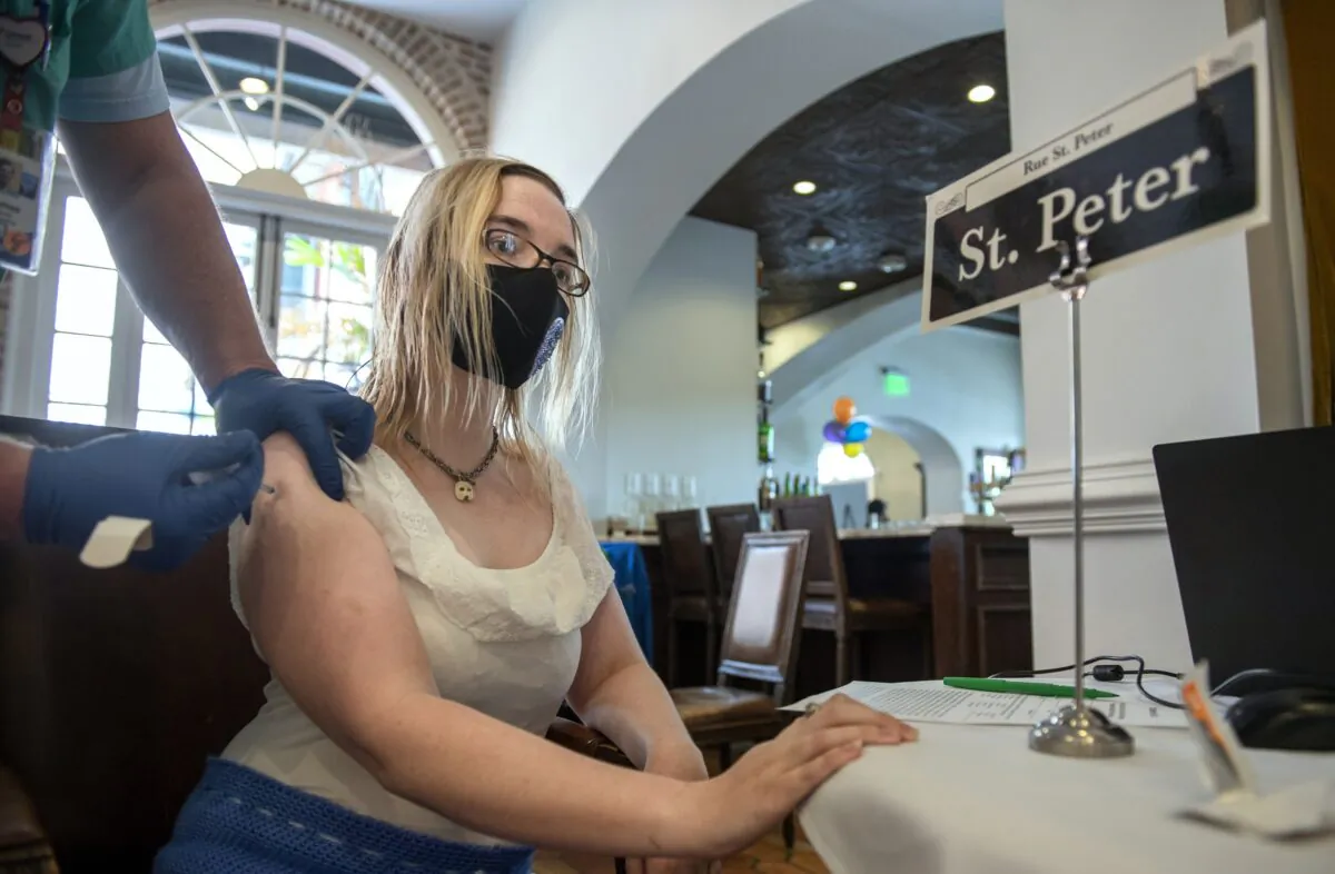 A nurse administers a COVID-19 vaccine to a woman at Tableau restaurant in the French Quarter of New Orleans, La., on April 13, 2021. (Chris Granger/The Times-Picayune/The New Orleans Advocate via AP)
