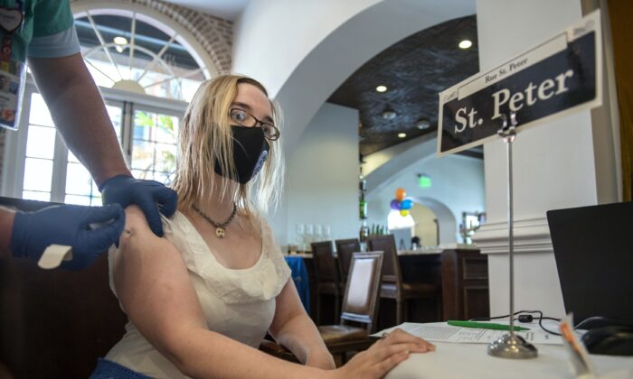 A nurse administers a COVID-19 vaccine to a woman at Tableau restaurant in the French Quarter of New Orleans, La., on April 13, 2021. (Chris Granger/The Times-Picayune/The New Orleans Advocate via AP)