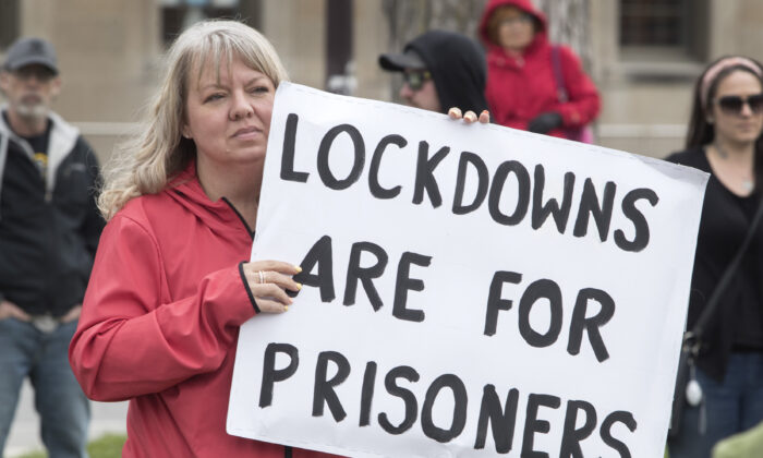 In a file photo, demonstrators march at a protest against COVID-19 restrictions, in Peterborough, Ont., on April 24, 2021. Several anti-lockdown protests were held in different cities in Canada on May 15. (The Canadian Press/Fred Thornhill)