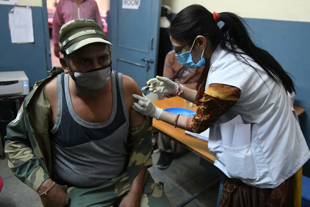 A medical worker inoculates a Border Security Force (BSF) personnel with a dose of the Covishield, ChAdOx1 nCoV-19 coronavirus vaccine, at a civil hospital in Ajnala village, about 28 km from Amritsar on April 1, 2021, as India expanded its coronavirus vaccination drive to the 45-60 age group. (Narinder Nanu/AFP) 